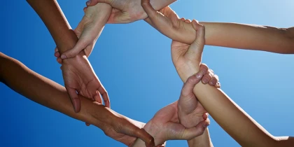 Hände halten sich aneinaner in einem Kreis fest