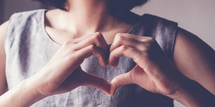 Frau bildet mit ihren Händen ein Herz